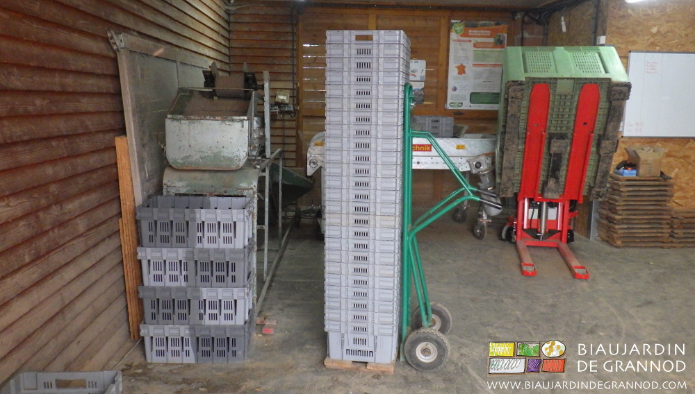 photo d'une pile de cagettes vides avec le diable glissé dessous pour les transporter