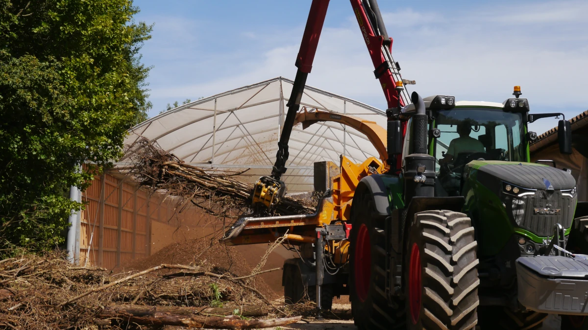 photo de la déchiqueteuse au travail devant le stockage plaquette