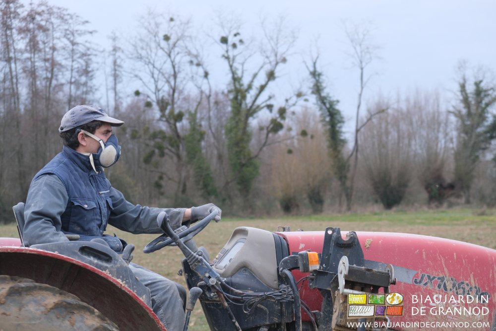 photo de Vivien conduisant le tracteur avec un masque pour épandre la chaux