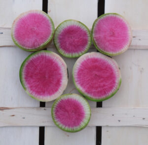 photo de radis à chair rouge tranché sur cagette bois
