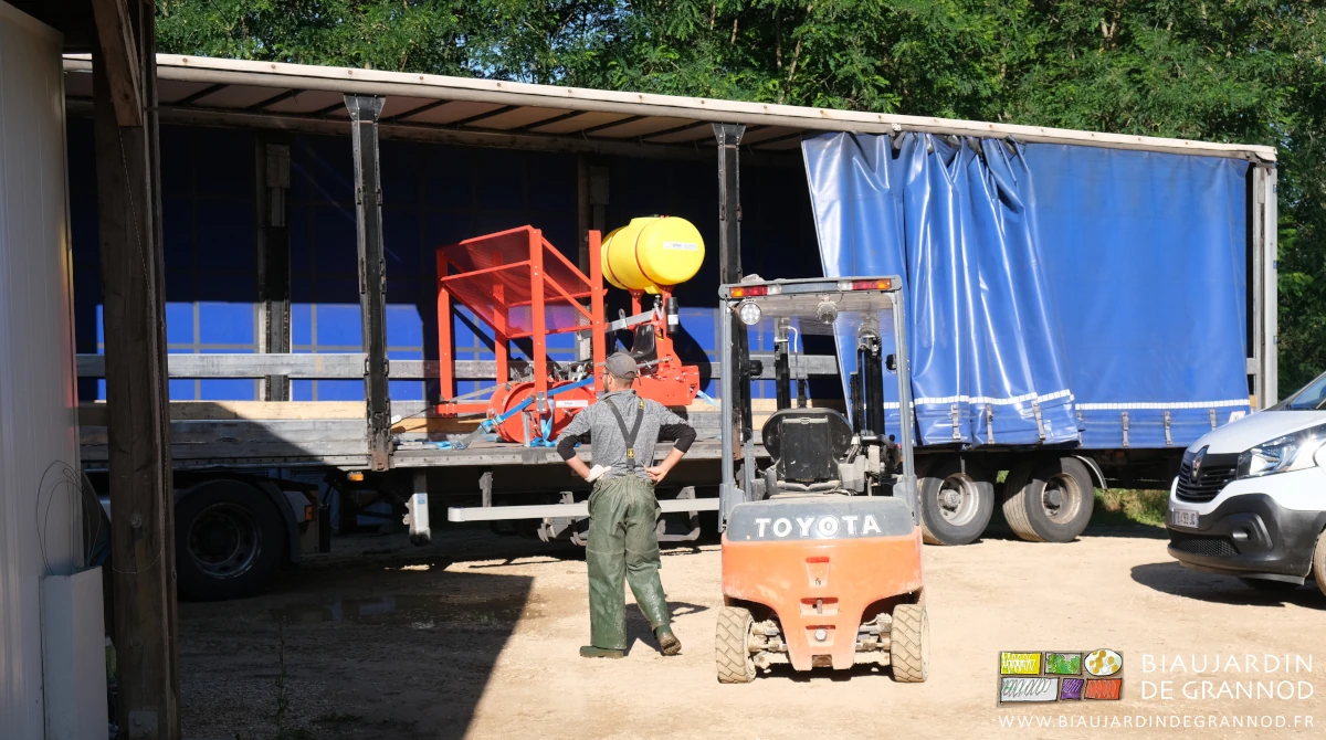 photo du semi-remorque livrant la planteuse et Matthieu en pantalon à bretelle imperméable