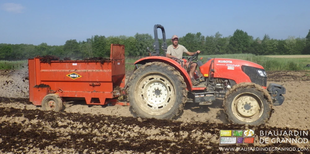 photo de Matthieu épandant le fumier composté sur des planches d'engrais vert