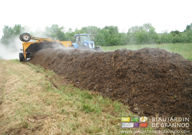 photo du retournement mécanique du tas de compost en fermentation