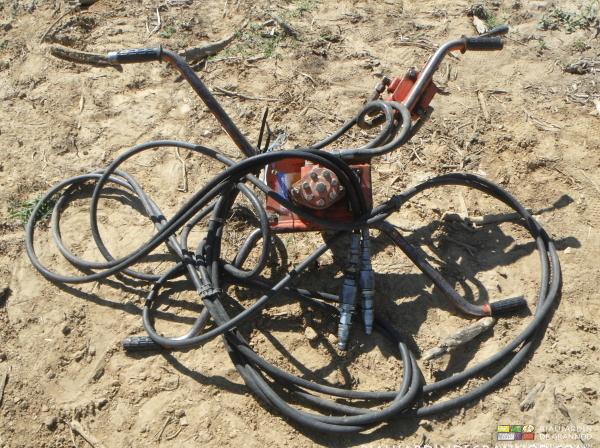 photo de la tarière hydraulique avec ses flexibles et poignée de maintien