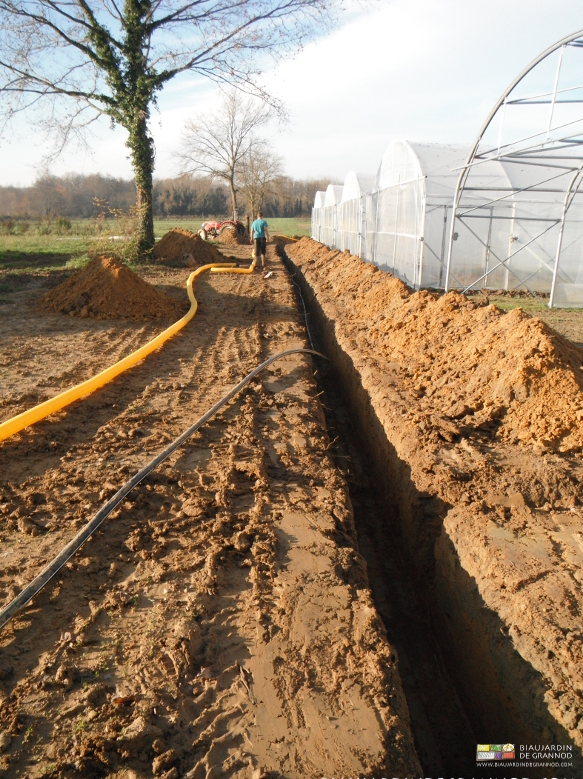 photo sous le soleil de Matthieu installant l'arrosage en tranchée