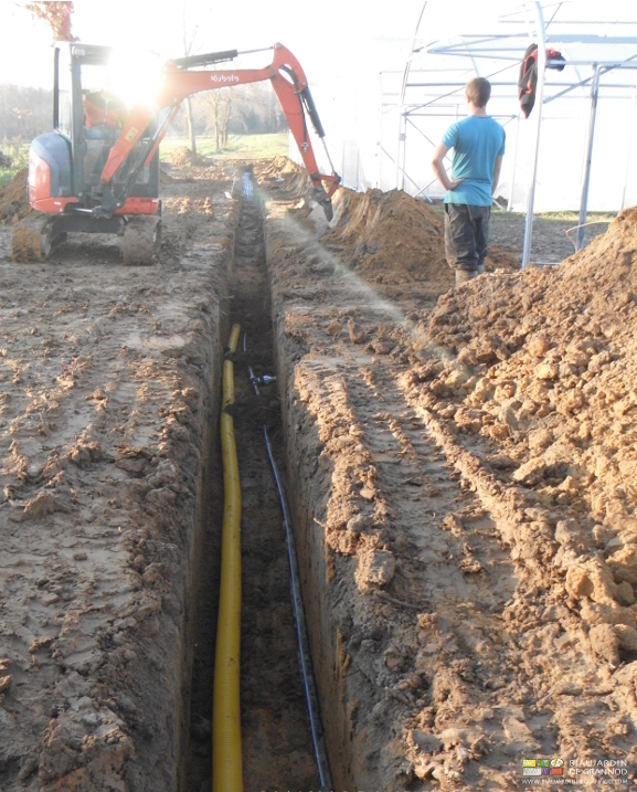 photo de la pelleteuse qui réparti un peu de terre sur les tuyaux