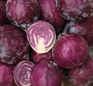 chou rouge coupé et choux rou ges entoers rangés dans une cagette bois