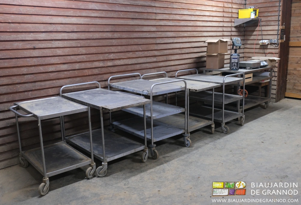 photo des tables roulantes rangées devant le bardage bois du local de préparation légumes