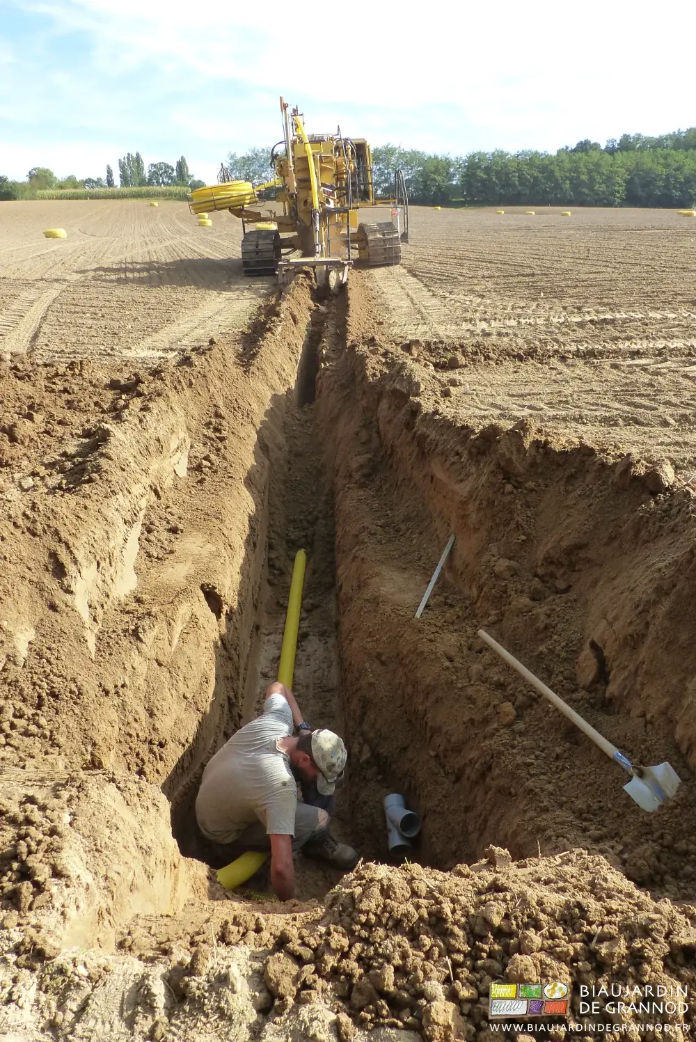 photo de l'accompagnateur qui retient le drain en fond de tranchée au démarrage