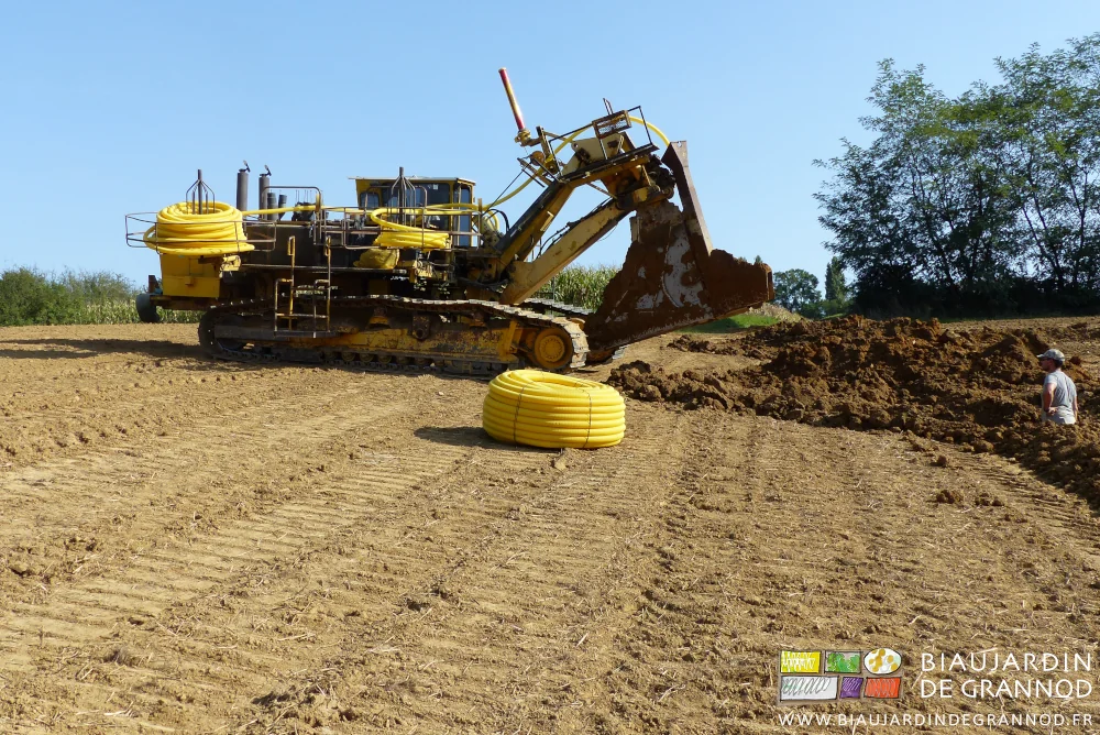 photo du sous-soleur reculant se mettre en position de départ dans la fosse creusée par la pelleteuse