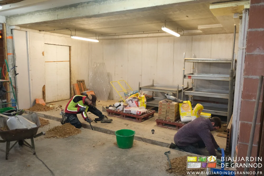 photo de Matthieu et Pierre qui dégagent l'isolant entre dalles pour le remplacer et fixer la nouvelle ossature