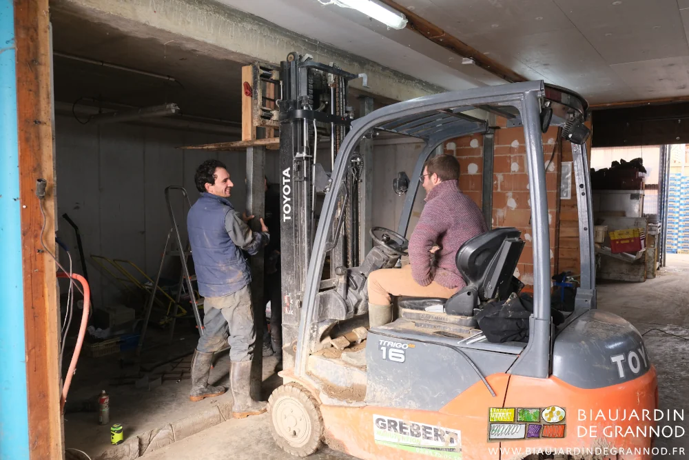 photo de Matthieu au chariot élévateur et Vivien qui ajuste le poteau en place