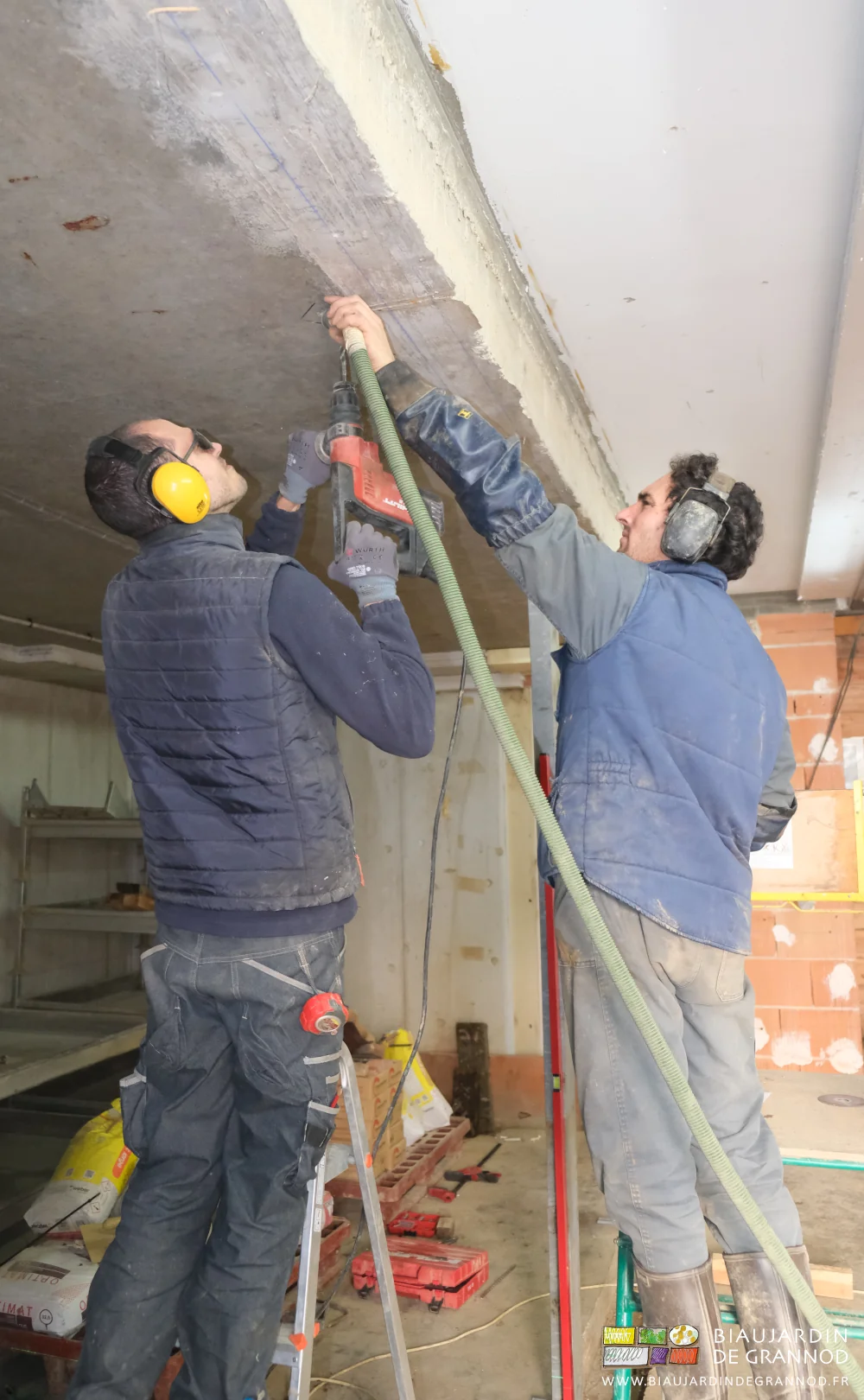 photo de Vivien tenant le tuyau d'aspirateur à côté de la mèche que Pierre actionne au perfo