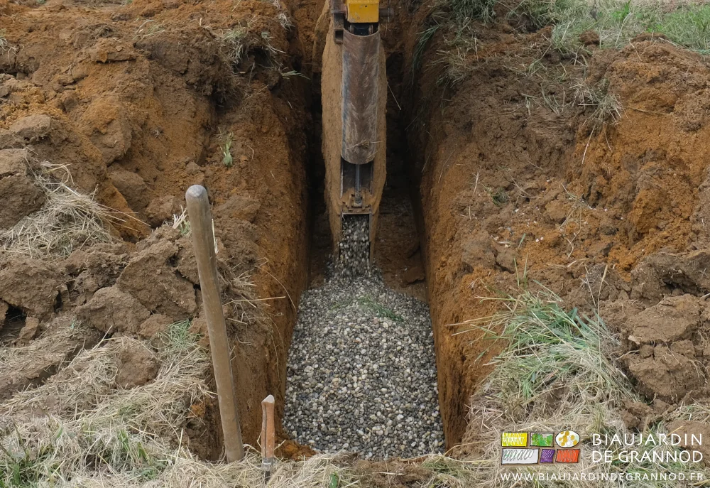 photo d'une tranchée de raccord dont le drain est couvert de gravier.