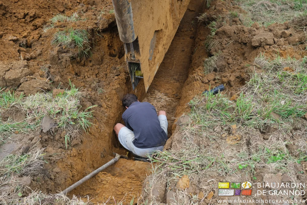photo de la pose manuelle du début du drain dans le coude de raccord au collecteur
