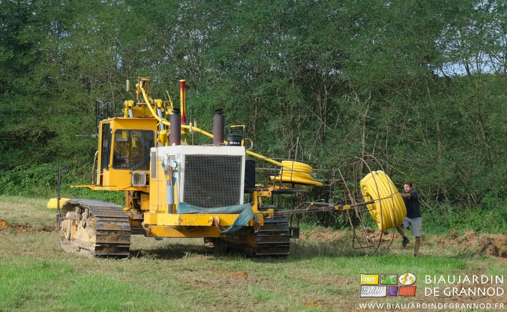photo du conducteur de draineuse chargeant un rouleau à l'aide de bras et jambes