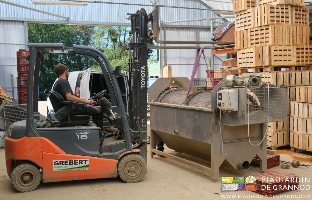photo de Matthieu soulevant avec le charriot élévateur la cuve sanglée.