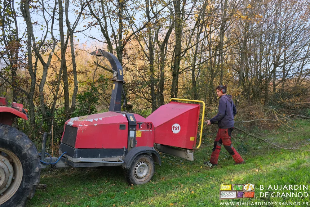 photo de Benhjamin poussant des branches dans la goulotte d'amenée de son broyeur