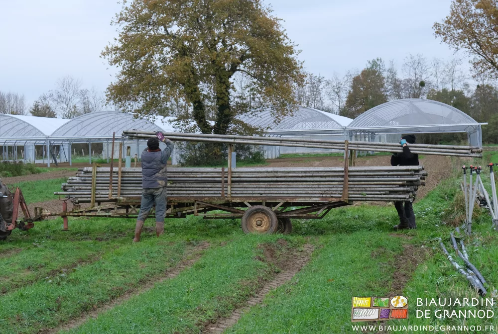 photo de Vivien et Alice rangeant les tubes d'arrosage longs de 6 mètres sur leur remorque de stockage