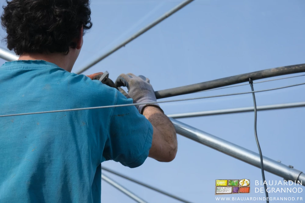 photo de mai,ns gantées qui installent un arroseur