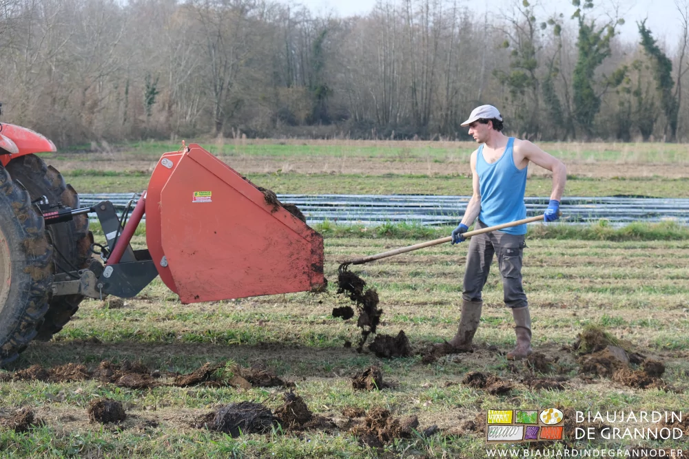 photo de Vivien en Marcel bleu tirant du fumier au croc