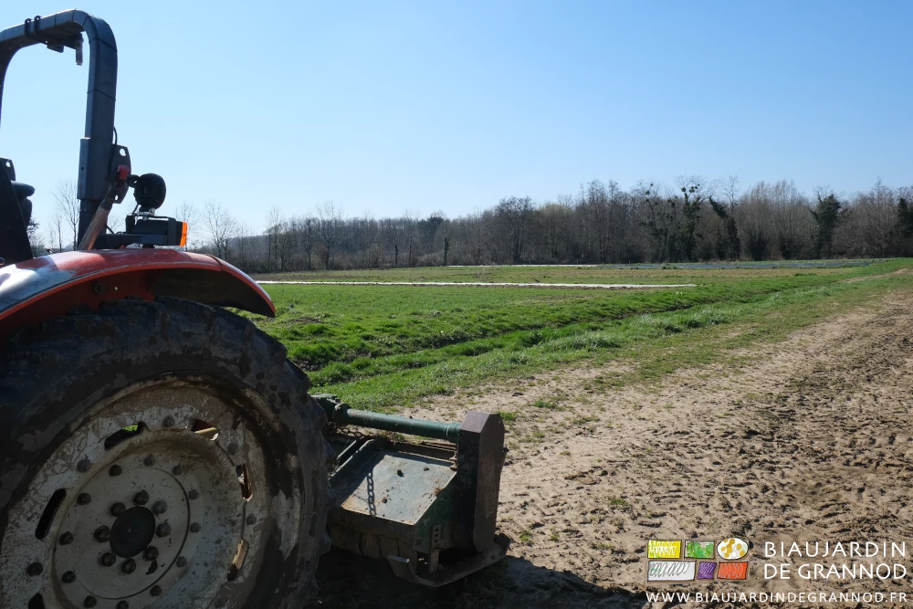 photo du broyeur attelé au tracteur sur fond du jardin et ses haies bocagères