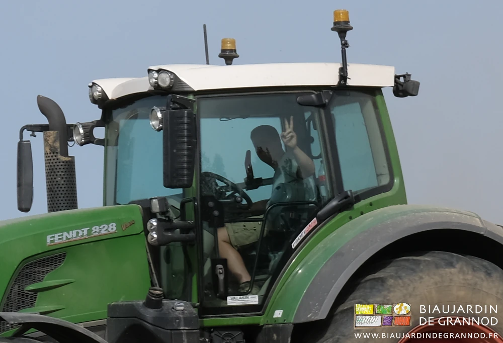photo de Romi juché sur son gros tracteur nous saluant d'un de victoire