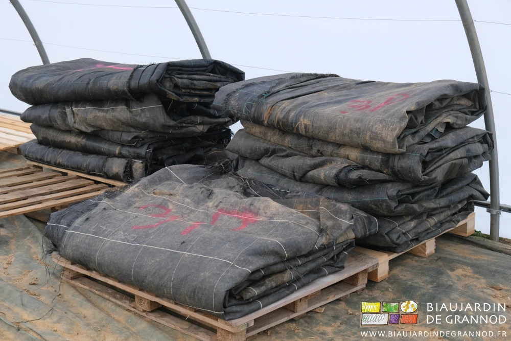 photo des toiles pliées empilées sur palette sous un ancien tunnel couvert en blanc