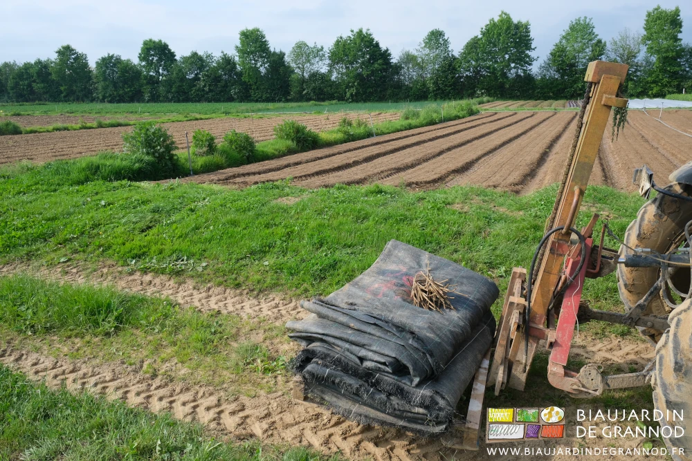 photo d'une pile de toile noire tissée portée par le mât lève-palette du tracteur