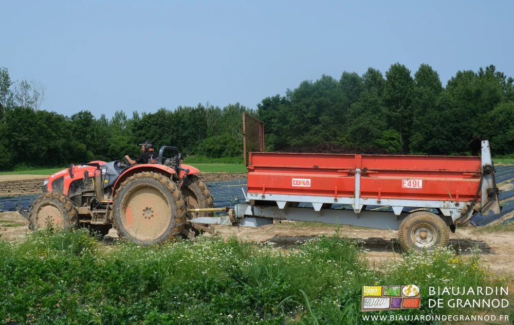 photo de tracteur amenant l'épandeur vers la parcelle de jardin