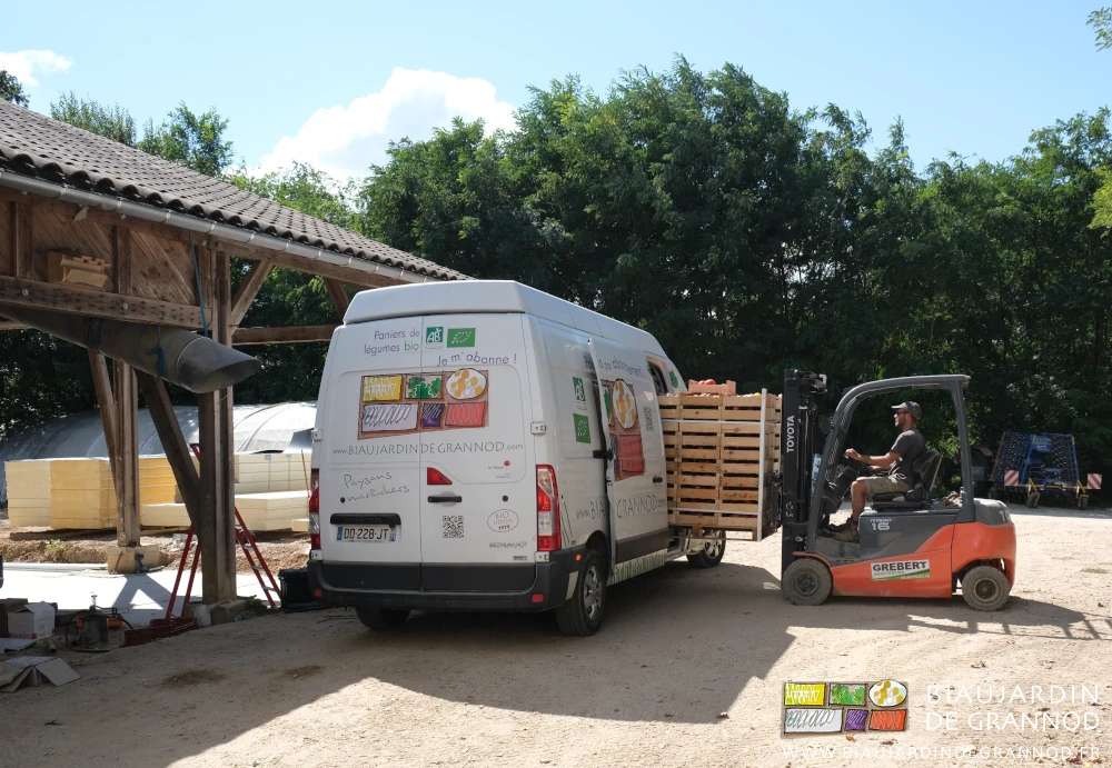 photo de Matthieu chargeant avec le chariot une palette de légumes dans le fourgon