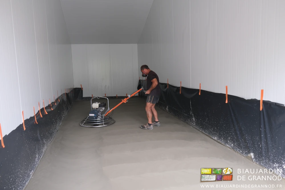 photo de Richard maintenant l'outil dont les pales tournent en talochant le béton