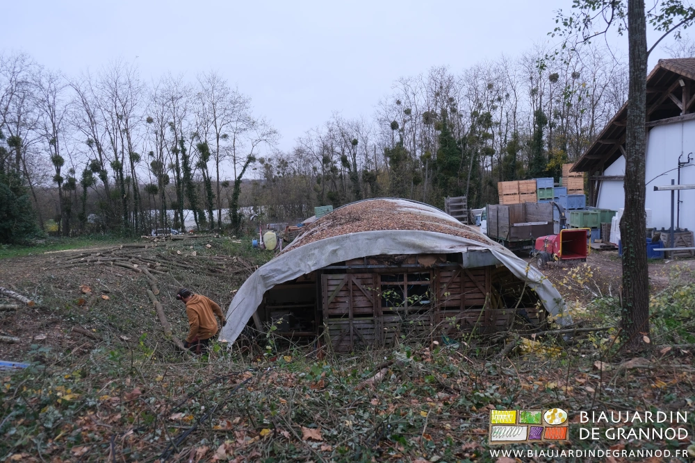 photo de benjamin au travail de tronçonneuse en pignon de l'abri tunnel