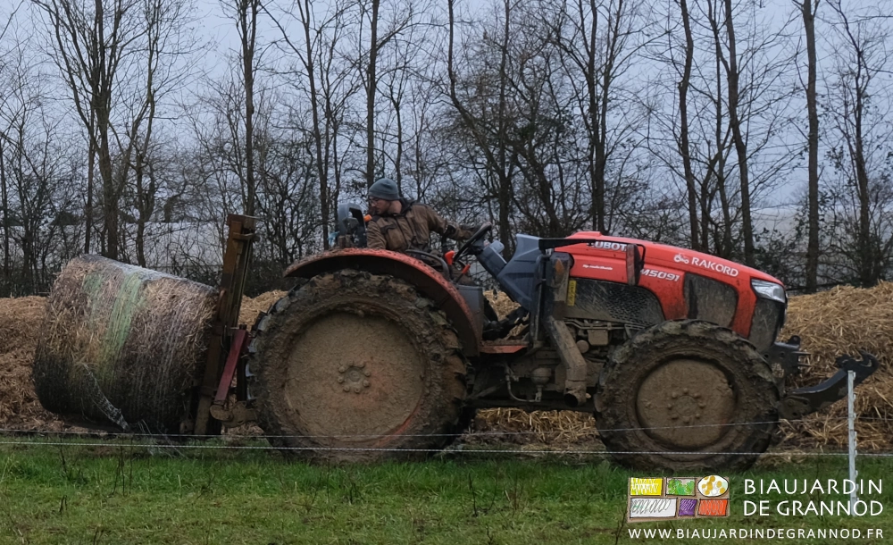 photo de Matthieu manipulant une botte ronde de paille avec le mât lève-palette