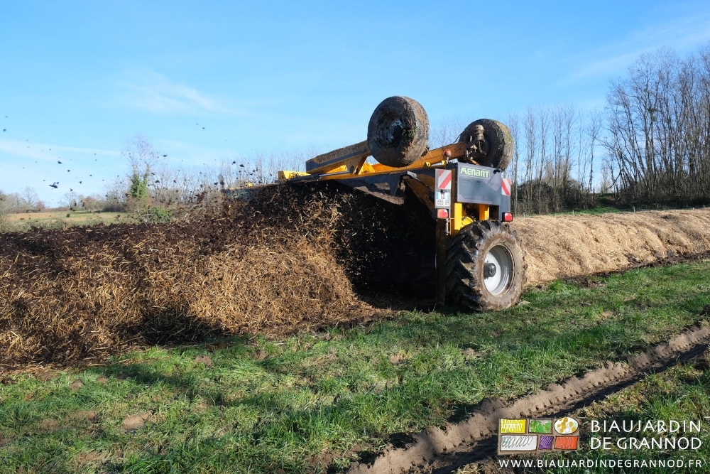 photo sous soleil et ciel bleu du rotor de retourneur mélangeant la paille au fumier en aérant le tas