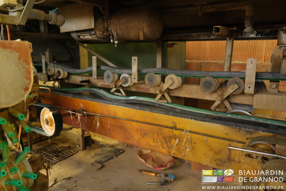 photo proche d'une des courroies en place entre roulettes, guides et pignons