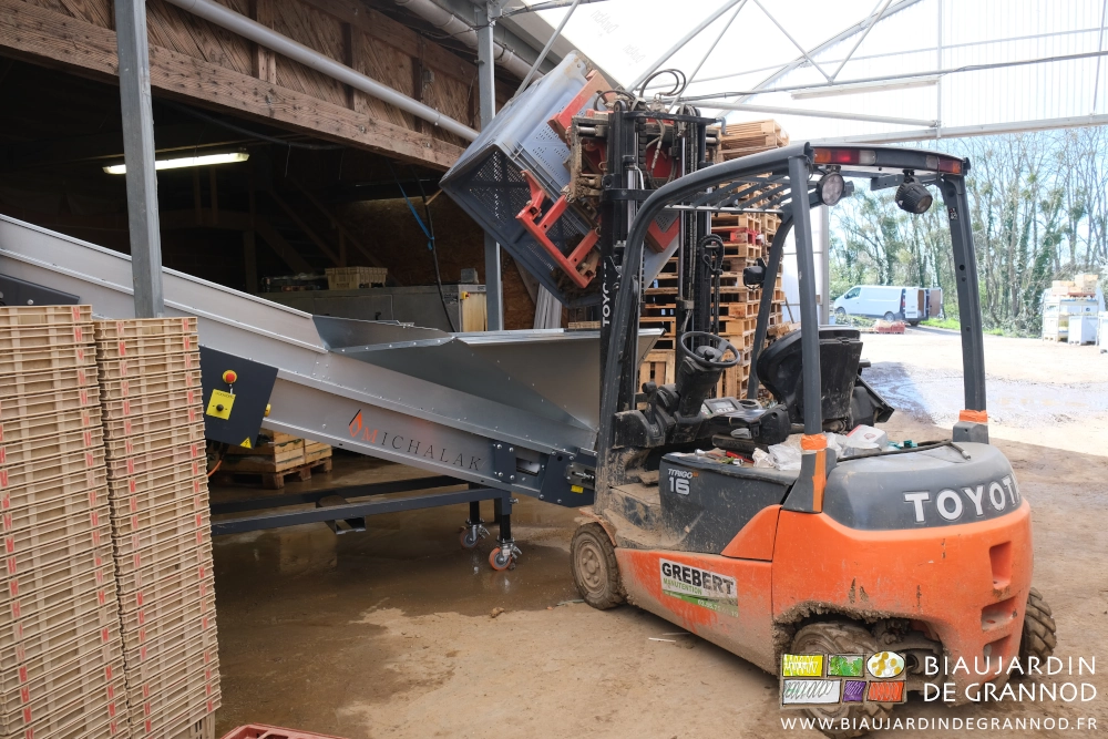 photo du palox maintenu en hauteur et basculé pour verser dans la trémie