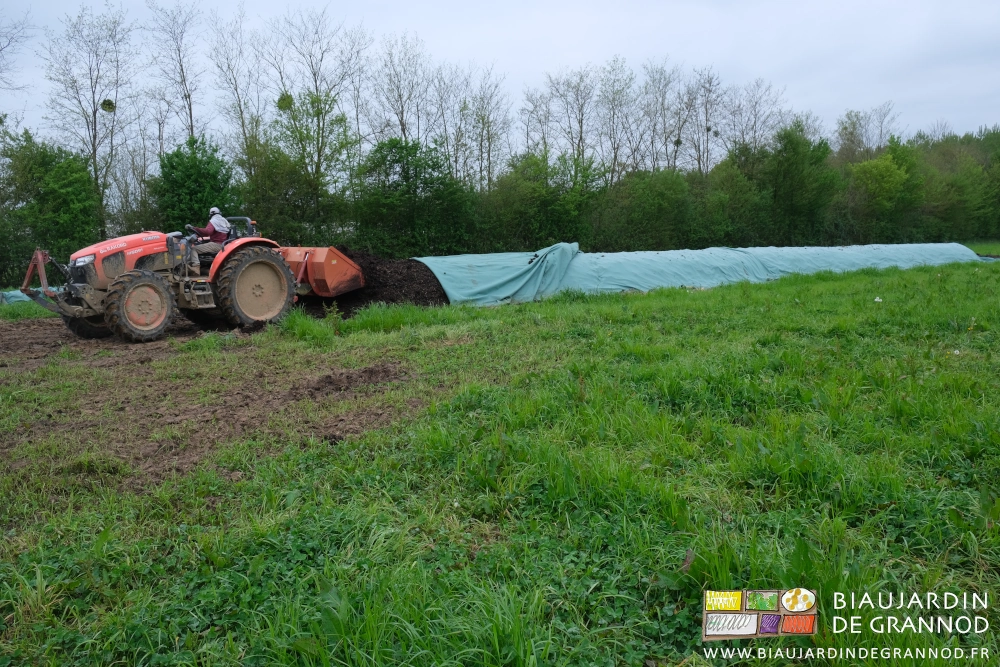 photo du tracteur qui recule dans le tas puis lève la benne pour la remplir