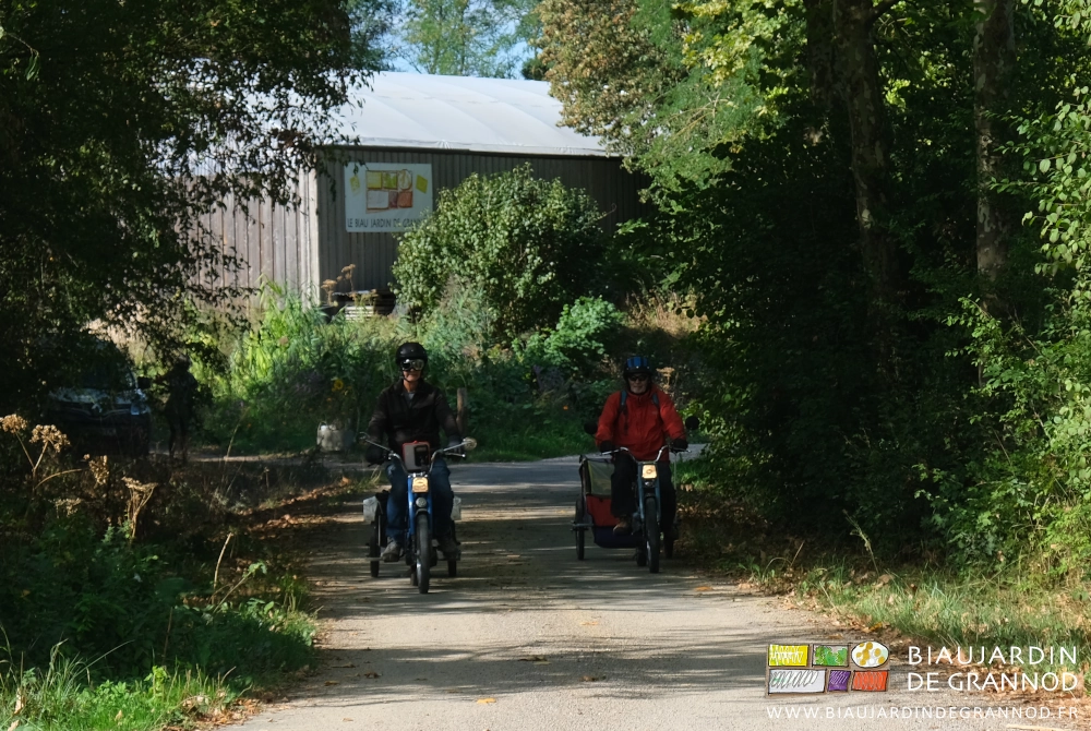 photo départ motorisé dans le chemin de la ferme, le bâtiment chapelle en fond